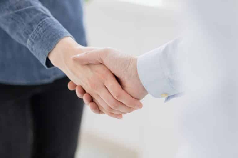 handshake of a man and a woman on a light background or handshake of two business partners